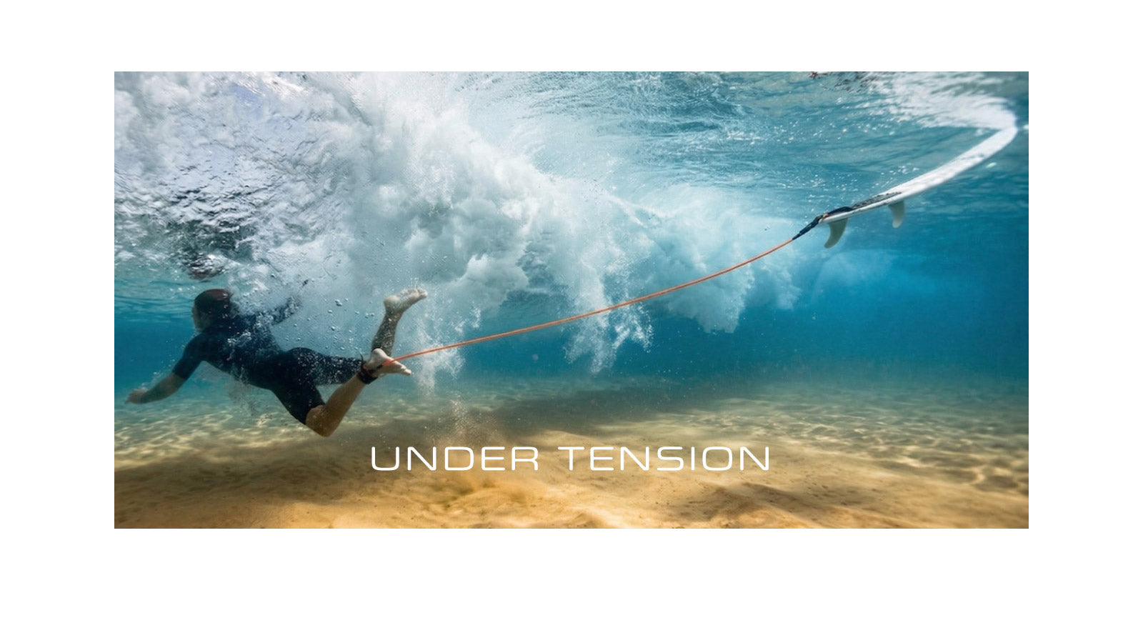 Underwater view of a surfer being pulled along the sandy seabed by a stretched orange surfboard leash connected to a board above the surface during a wipeout, with the text "Under Tension" overlaid on the image