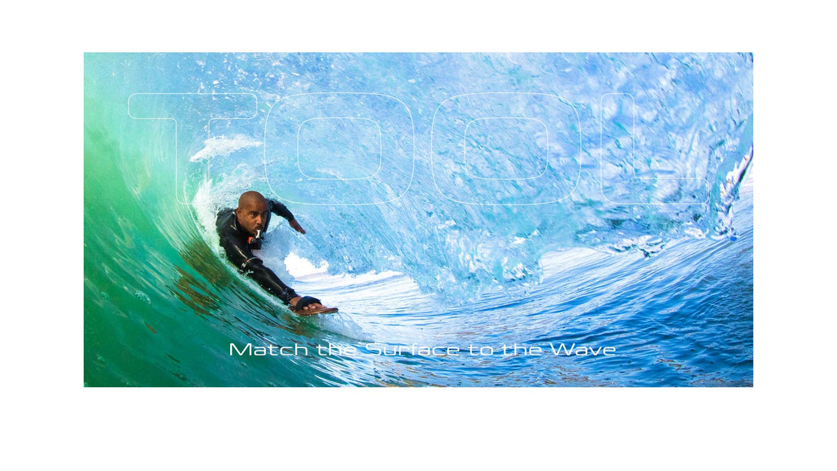A bodysurfer riding deep inside a large hollow green wave holding a POD handboard, with the word "TOOL" overlaid in large outline lettering and the text "Match the Surface to the Wave" below