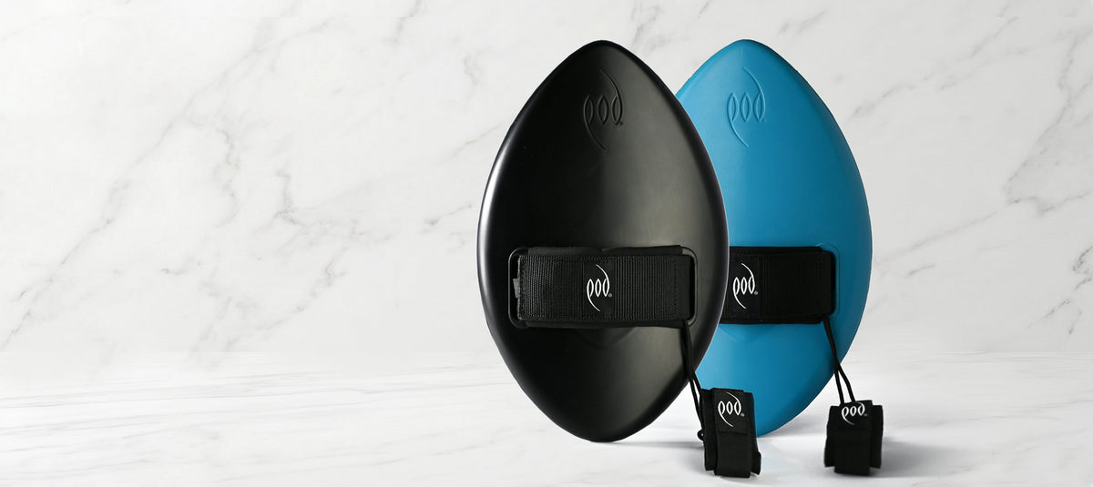 Two POD Handboards body surfing boards, a black WOW handplane and a blue WOW handboard both with black hand and wrist straps, displayed on a light marble surface.