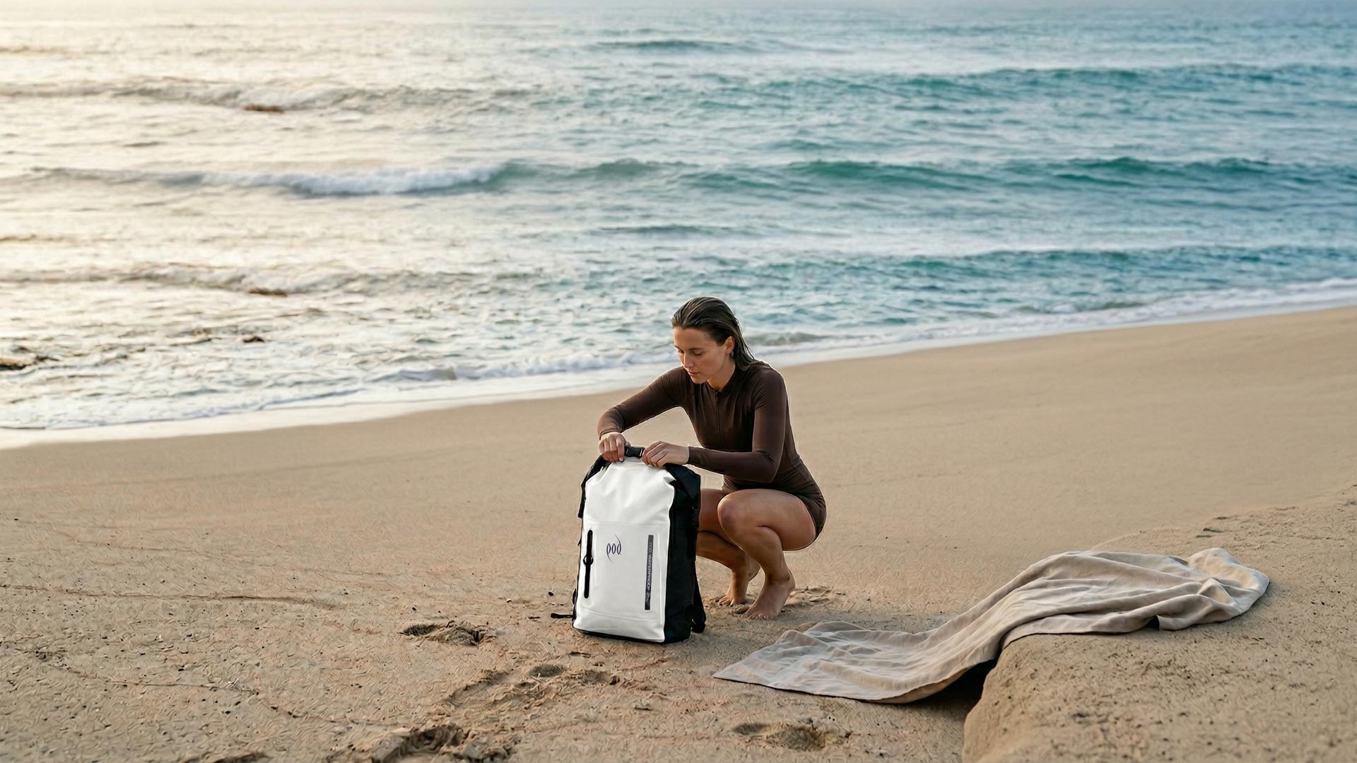 Lady at the beach unpacking a POD waterproof backpack