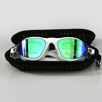 White swim goggles with green-tinted reflective lenses, displayed inside an open black zippered case on a light gray background.